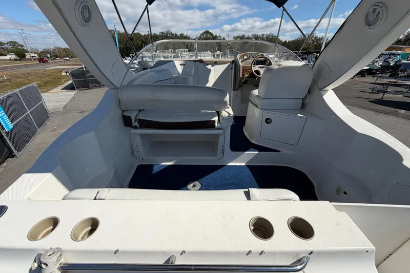 Slide: The Image of 2003 Bayliner 2855 Ciera boat interior with seating and steering wheel, docked outdoors. - 11