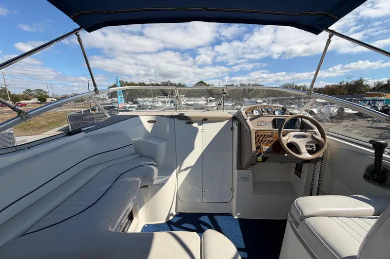 Slide: The Image of 2003 Bayliner 2855 Ciera boat interior with steering wheel and seating under blue sky. - 14