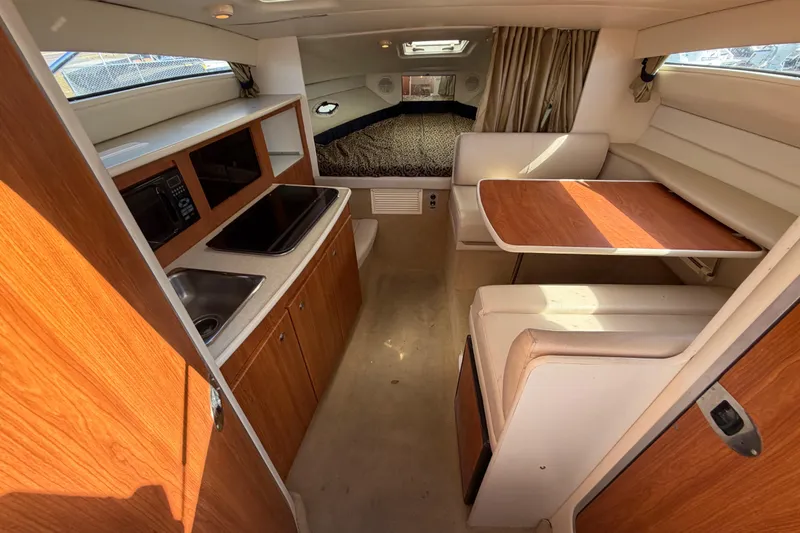 Slide: The Image of 2003 Bayliner 2855 Ciera interior with kitchenette, dining area, and sleeping quarters. - 29