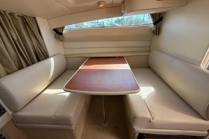 Slide: The Image of Interior of 2003 Bayliner 2855 Ciera with beige seating and wooden table. - 34