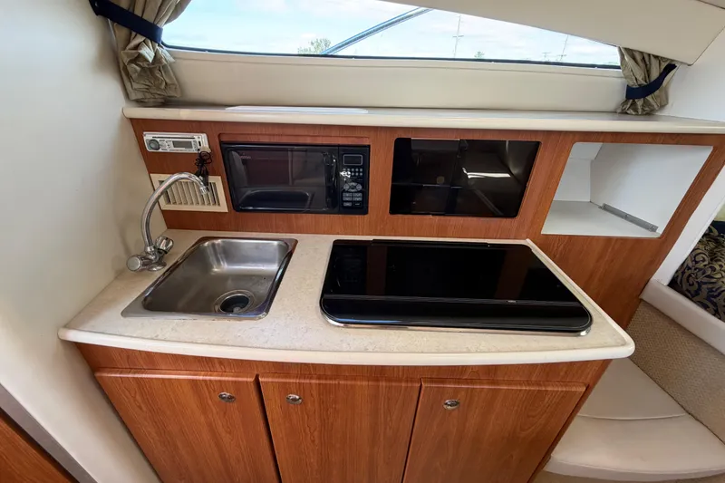 Slide: The Image of 2003 Bayliner 2855 Ciera boat kitchen with sink, microwave, and stove. - 35