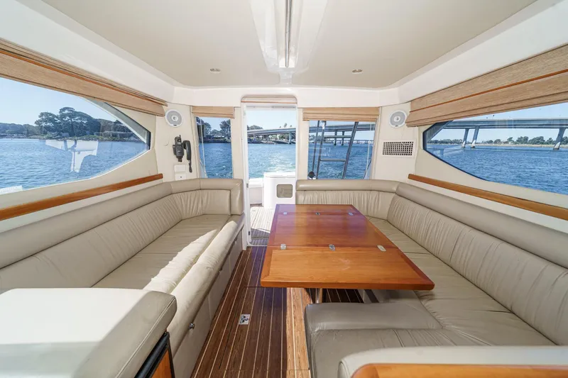 Slide: The Image of Interior of 2006 Riviera 33 Flybridge yacht with spacious seating and wooden table. - 26