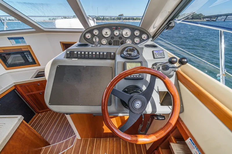 Slide: The Image of 2006 Riviera 33 Flybridge helm with wooden steering wheel and navigation controls. - 28