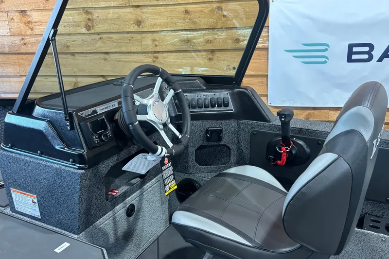 Slide: The Image of 2026 Lund 1875 Impact XS boat interior with steering wheel and control panel. - 3