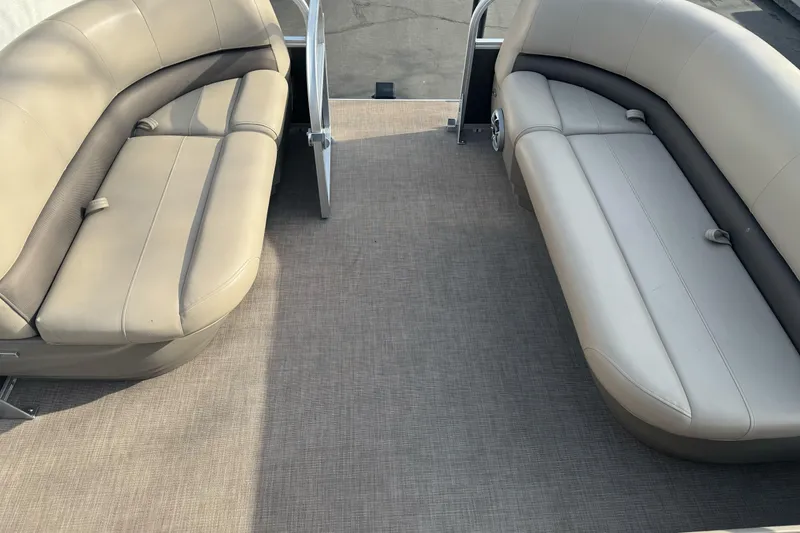 Slide: The Image of 2024 Sun Tracker Party Barge 16 DLX interior with beige seating and spacious layout. - 12