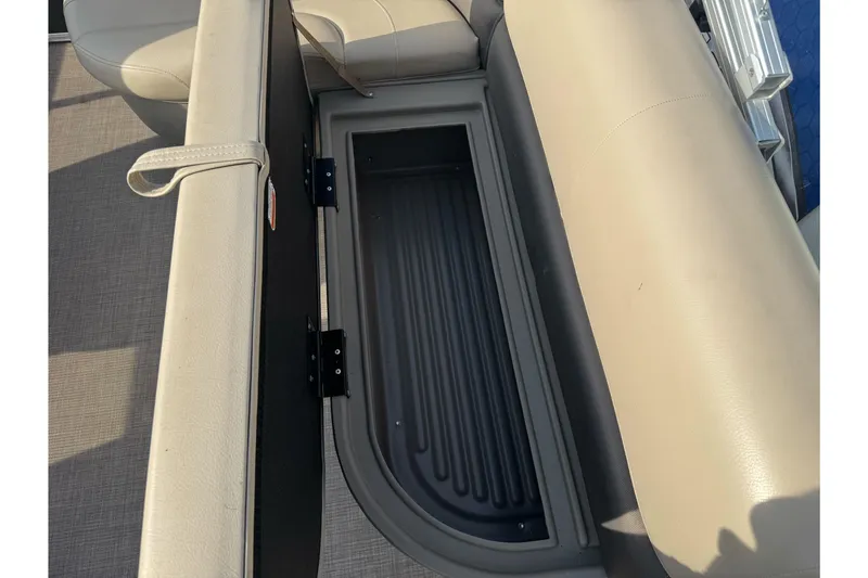 Slide: The Image of 2024 Sun Tracker Party Barge 16 DLX storage compartment with beige seating. - 14