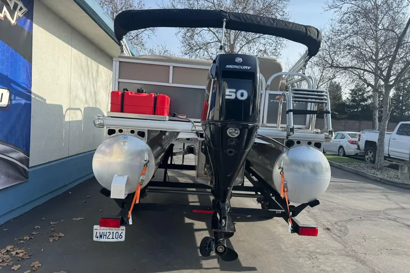 Slide: The Image of 2024 Sun Tracker Party Barge 16 DLX with Mercury 50 engine, parked outdoors. - 4