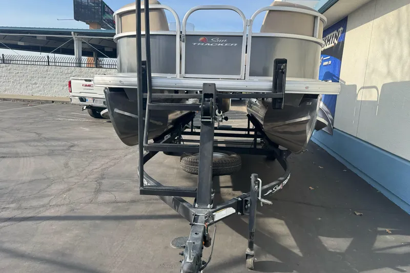 Slide: The Image of 2024 Sun Tracker Party Barge 16 DLX pontoon boat on trailer in parking lot. - 8