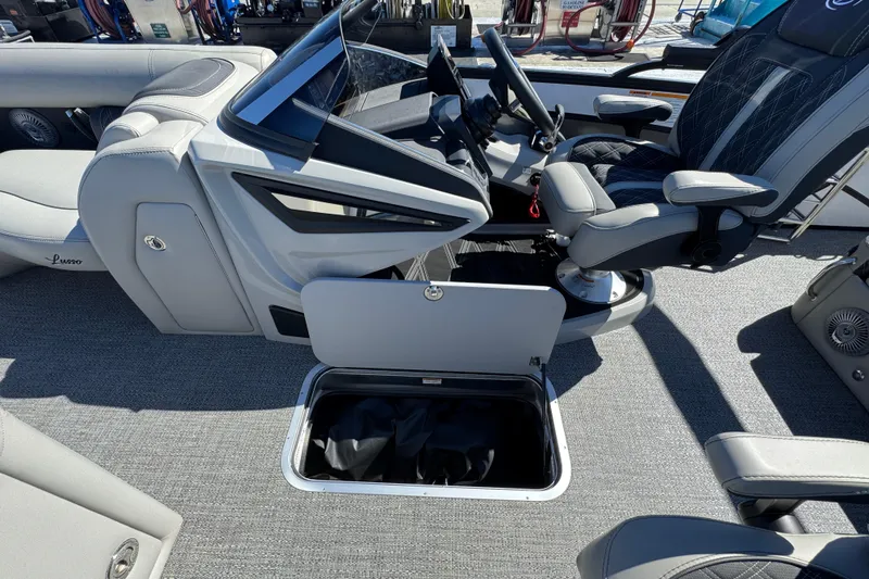 Slide: The Image of 2026 Barletta Lusso 23UC boat interior with open storage compartment and captain's chair. - 43