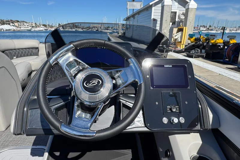 Slide: The Image of 2026 Barletta Lusso 23UC boat helm with steering wheel and Simrad display. - 47