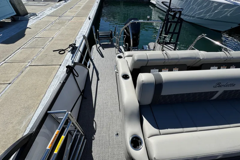 Slide: The Image of 2026 Barletta Lusso 23UC pontoon boat docked, featuring luxurious seating and sleek design. - 52