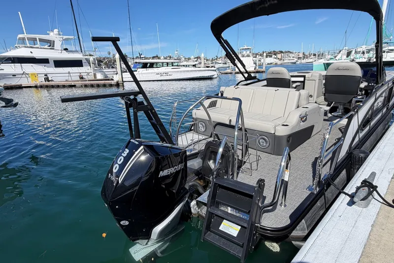 Slide: The Image of 2026 Barletta Lusso 23UC pontoon boat docked in a marina, featuring a Mercury outboard engine. - 62