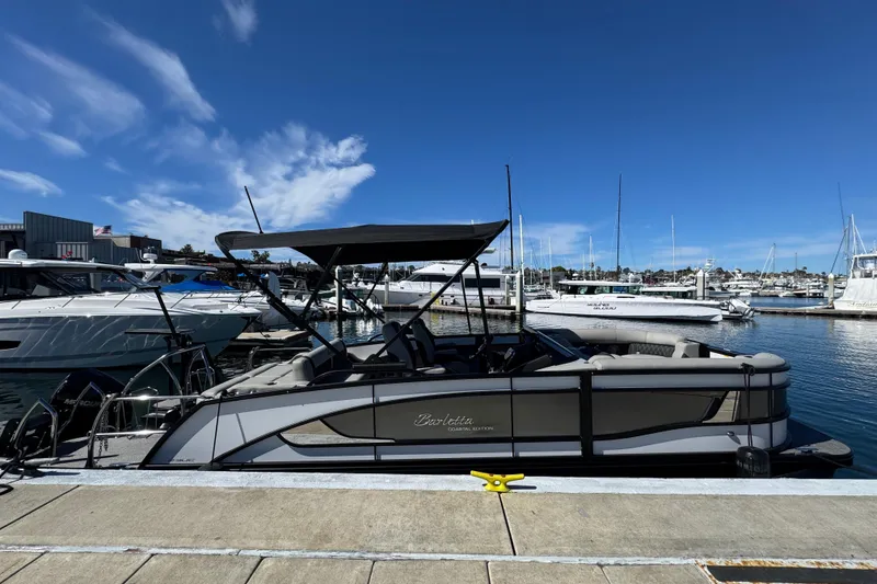 Slide: The Image of 2026 Barletta Lusso 23UC pontoon boat docked at a marina under a clear blue sky. - 72