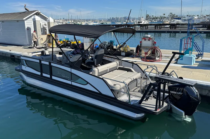 Slide: The Image of 2026 Barletta Lusso 23UC pontoon boat docked at marina with Mercury engine. - 77