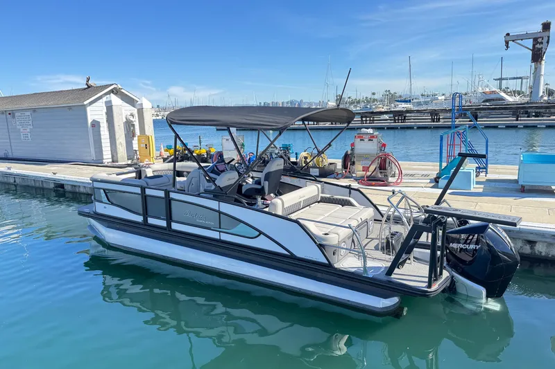 Slide: The Image of 2026 Barletta Lusso 23UC pontoon boat docked at marina, featuring sleek design and Mercury engine. - 82