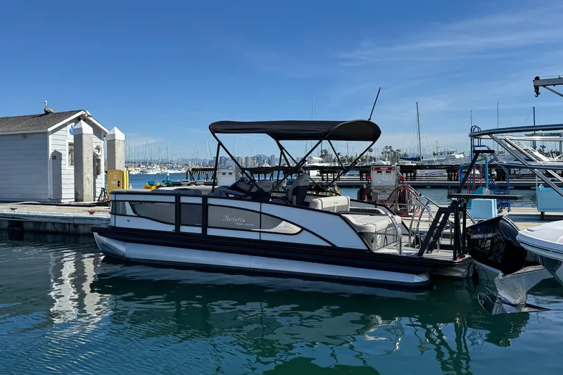 Slide: The Image of 2026 Barletta Lusso 23UC pontoon boat docked at marina under clear blue sky. - 84