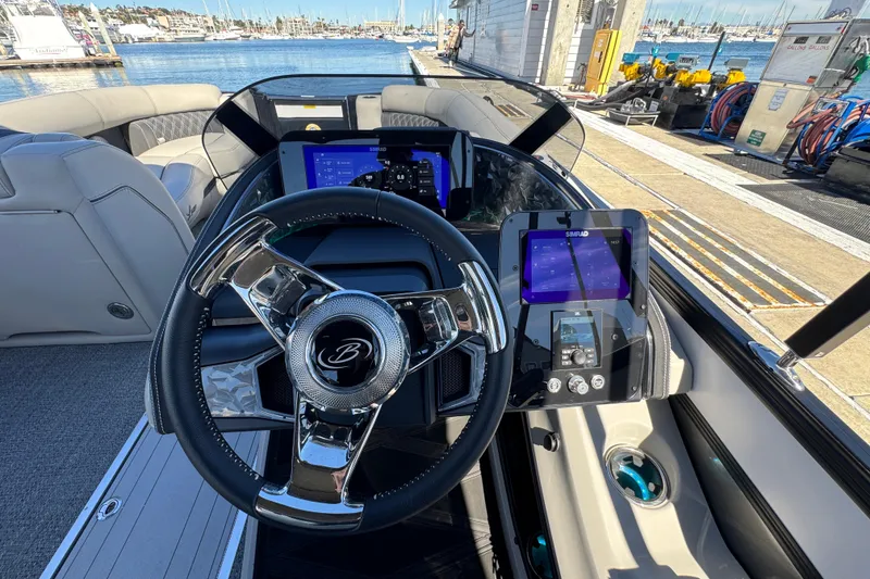 Slide: The Image of 2026 Barletta Lusso 23UC boat dashboard with modern steering and digital displays at marina. - 89