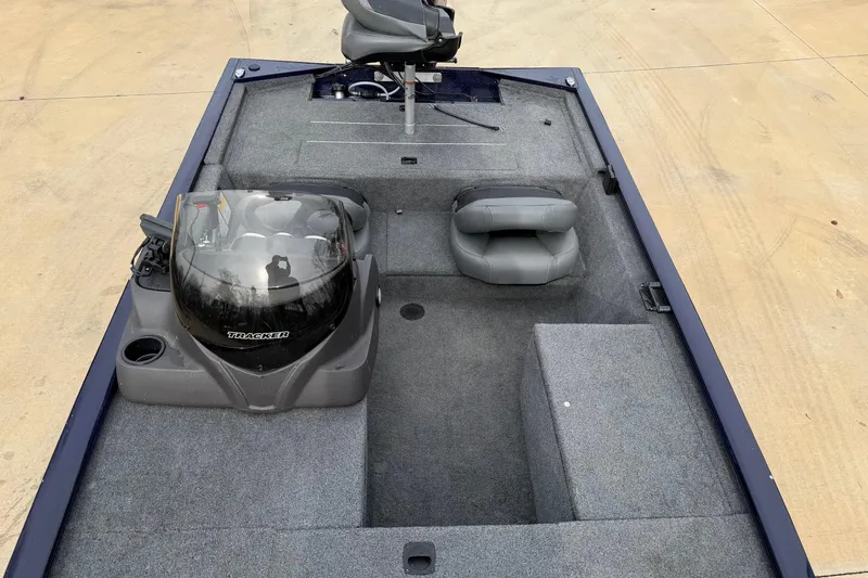 Slide: The Image of 2022 Bass Tracker Pro 170 boat interior with seating and console on concrete surface. - 4