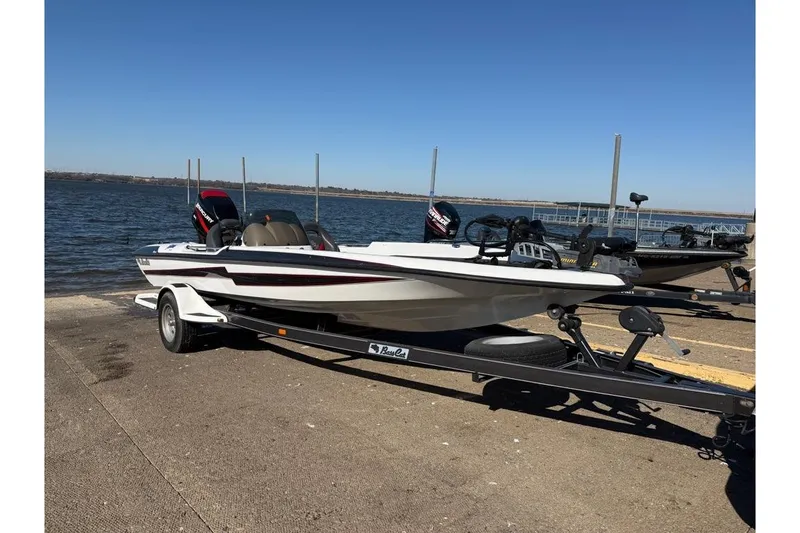The Image of 2005 Bass Cat Pantera Classic boat on trailer by a lake. - 1