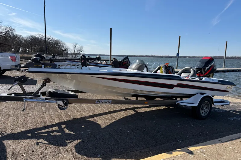 Slide: The Image of 2005 Bass Cat Pantera Classic boat on trailer by a lake. - 6