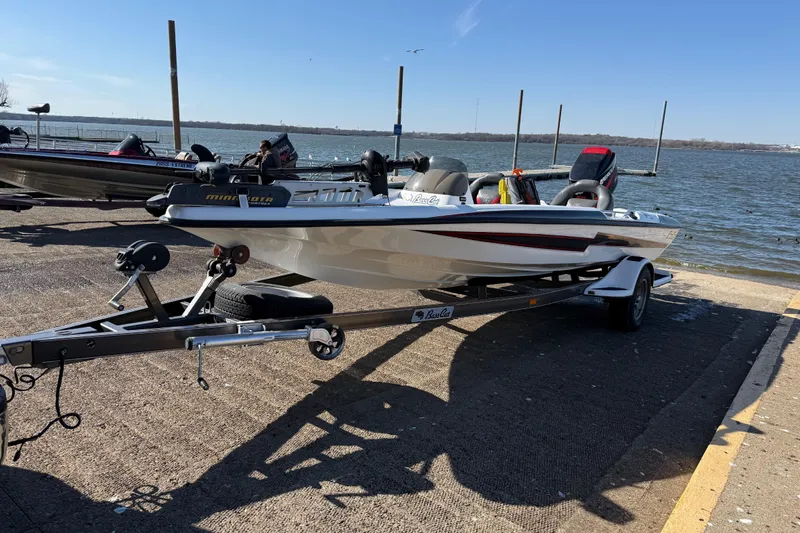 Slide: The Image of 2005 Bass Cat Pantera Classic boat on trailer by a lakeside dock. - 7