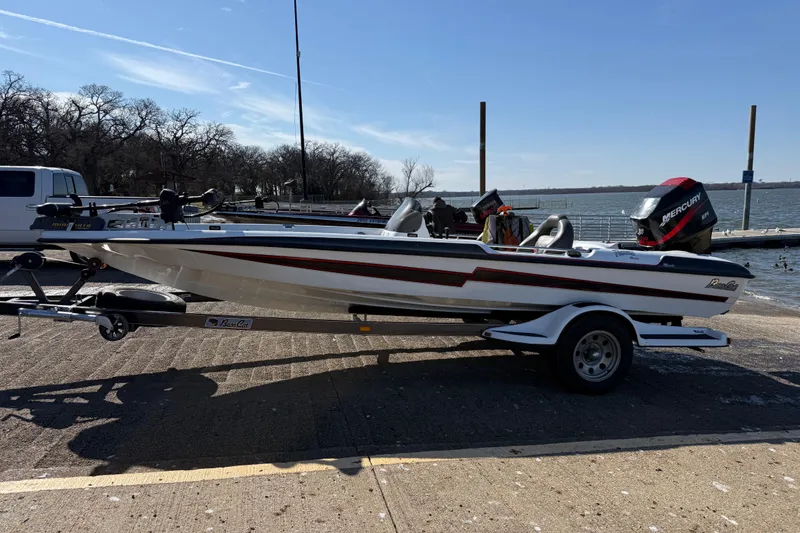 Slide: The Image of 2005 Bass Cat Pantera Classic boat on trailer by a lakeside dock. - 8