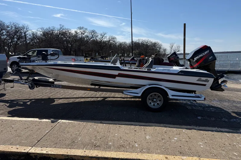 Slide: The Image of 2005 Bass Cat Pantera Classic boat on trailer, parked near a lake. - 9