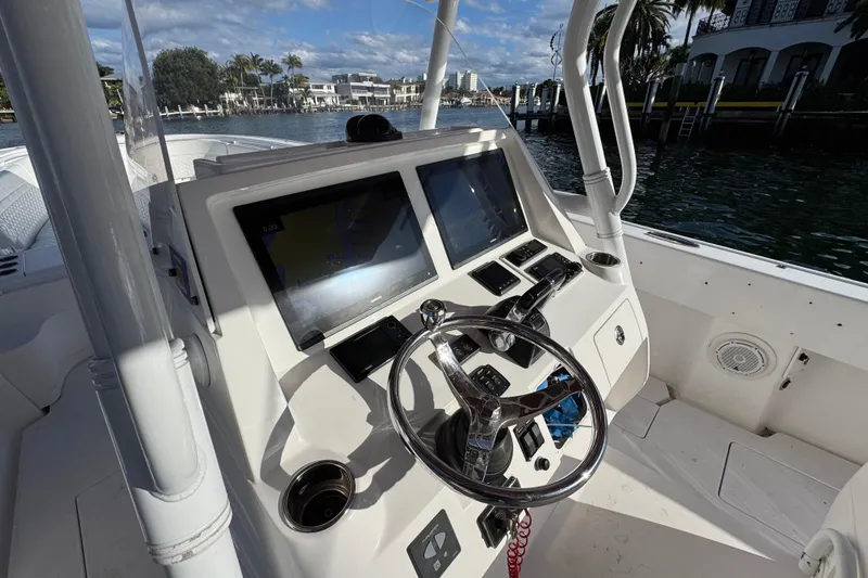 Slide: The Image of 2017 Intrepid 375 Center Console helm with dual screens and steering wheel, dockside view. - 10
