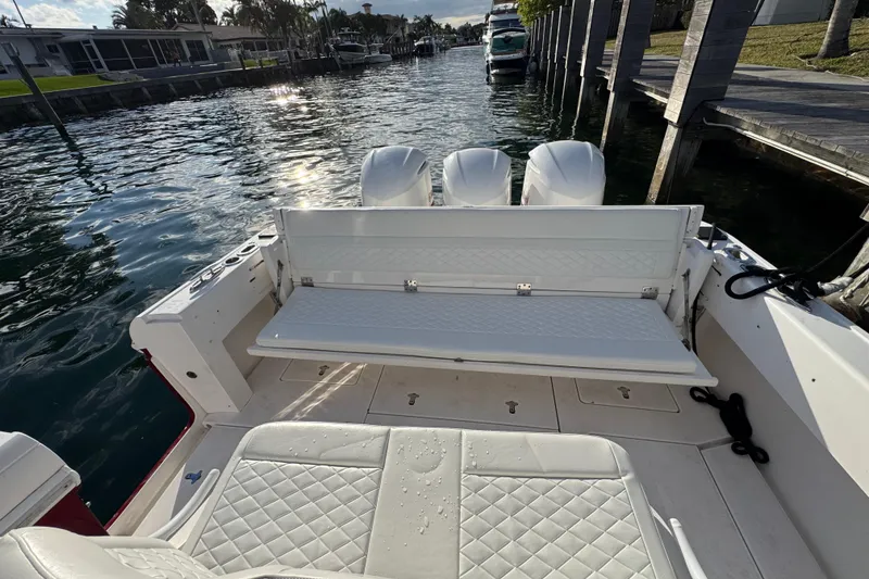 Slide: The Image of 2017 Intrepid 375 Center Console boat with white seating, docked by the water. - 19