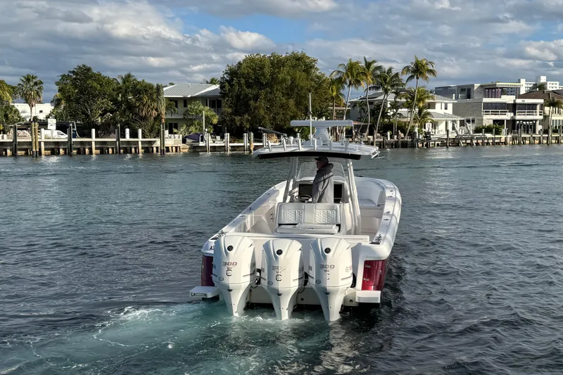 Slide: The Image of 2017 Intrepid 375 Center Console boat cruising on a scenic waterway. - 2