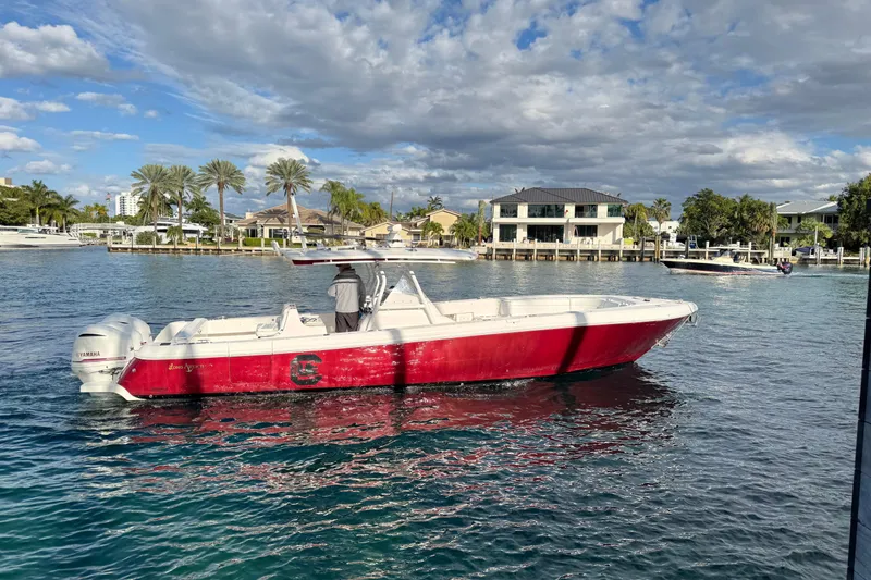 Slide: The Image of 2017 Intrepid 375 Center Console boat on water, red and white design, scenic waterfront background. - 3