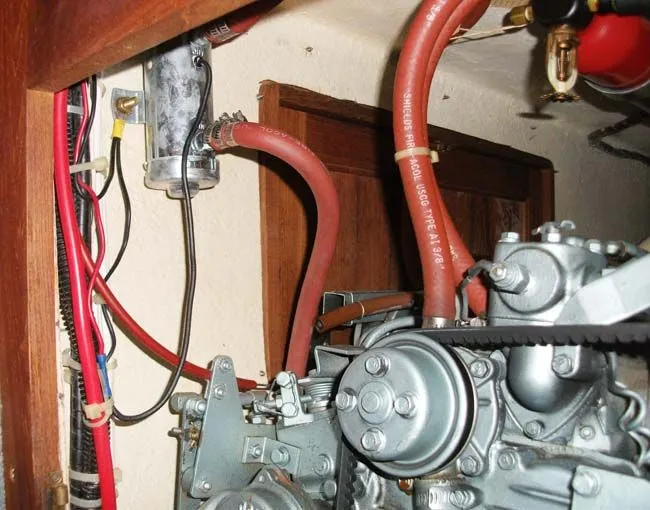 Slide: The Image of 1990 Catalina 27 engine compartment with hoses and wires. - 12
