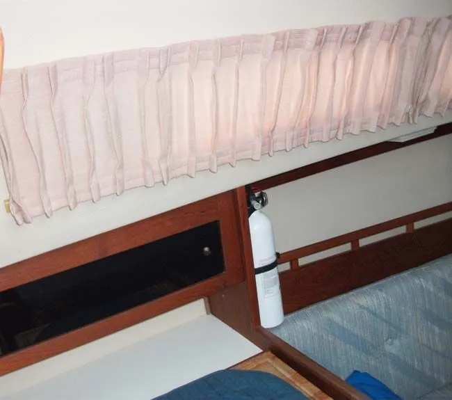 Slide: The Image of Interior of a 1990 Catalina 27 yacht with curtains and fire extinguisher. - 14