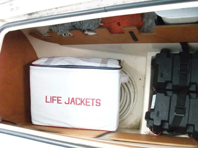 Slide: The Image of Catalina 27 boat storage with life jackets, rope, and battery. - 24
