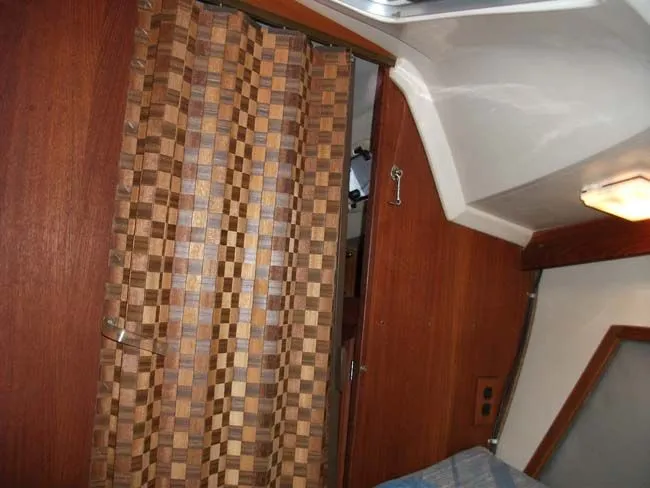 Slide: The Image of Interior of a 1990 Catalina 27 with wood paneling and curtain. - 43