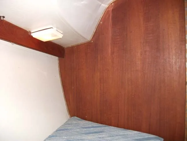 Slide: The Image of Interior of a 1990 Catalina 27 with wood paneling and bed. - 44