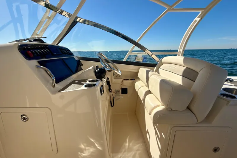 Slide: The Image of 2016 Grady-White Freedom 307 boat dashboard with steering wheel and navigation screens. - 10