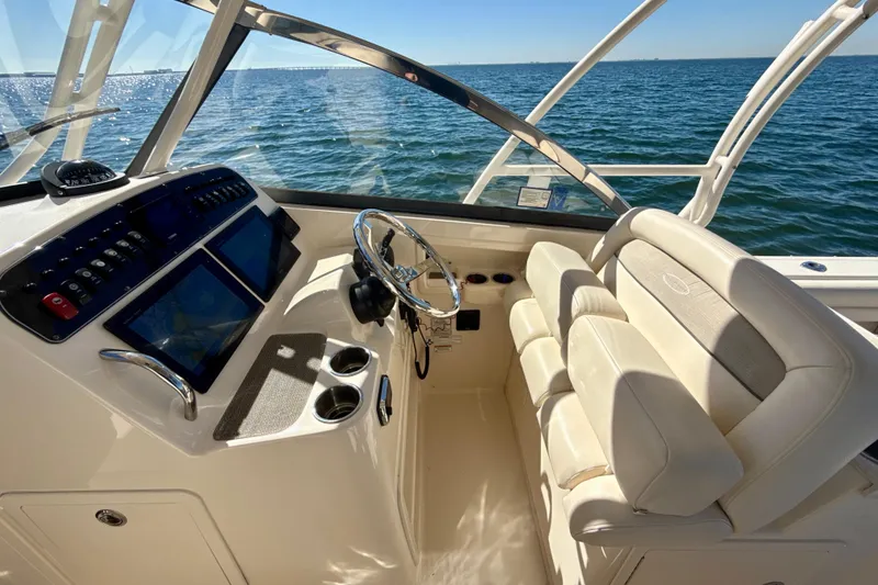 Slide: The Image of 2016 Grady-White Freedom 307 boat dashboard with navigation screens and ocean view. - 11