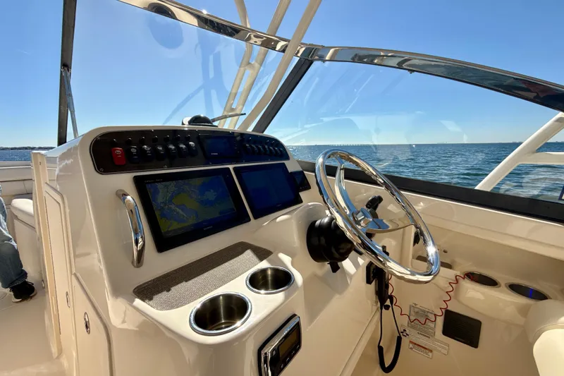 Slide: The Image of 2016 Grady-White Freedom 307 boat interior with seating, ocean view, and clear skies. - 13