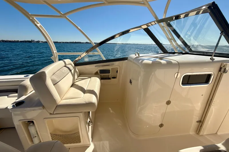 Slide: The Image of 2016 Grady-White Freedom 307 boat with cushioned seating, cruising on open water. - 16