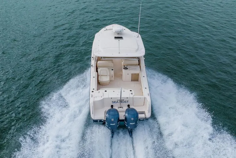 Slide: The Image of 2016 Grady-White Freedom 307 boat cruising on open water, rear view. - 31