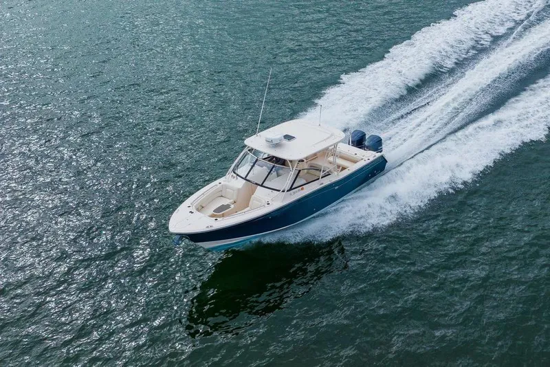 Slide: The Image of 2016 Grady-White Freedom 307 boat cruising on open water, creating a wake. - 37