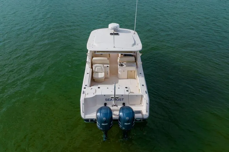 Slide: The Image of 2016 Grady-White Freedom 307 boat on calm green water, rear view. - 40