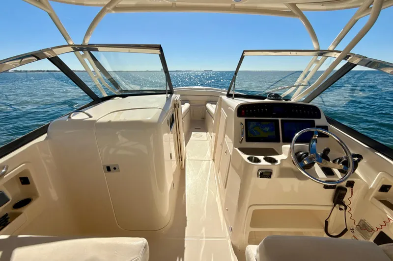 Slide: The Image of 2016 Grady-White Freedom 307 boat interior with steering wheel and seating, on open water. - 9