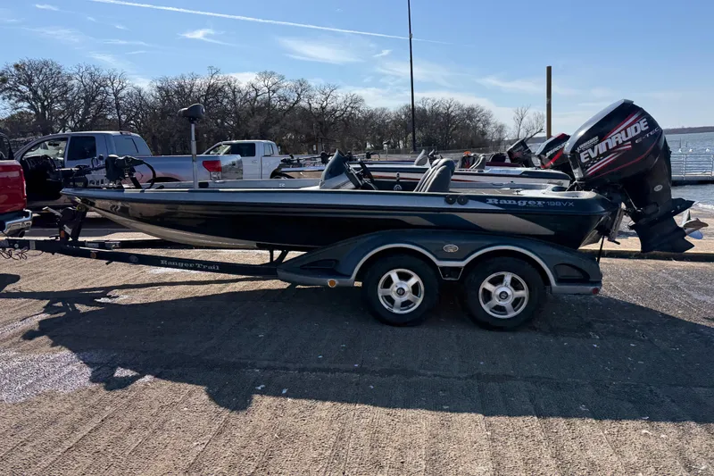 Slide: The Image of 2008 Ranger 198 VX boat with Evinrude engine, hitched to a red truck in a parking lot. - 11