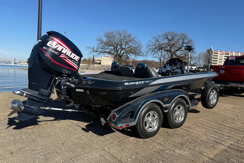 Slide: The Image of 2008 Ranger 198 VX boat with Evinrude engine, parked near a waterfront. - 22