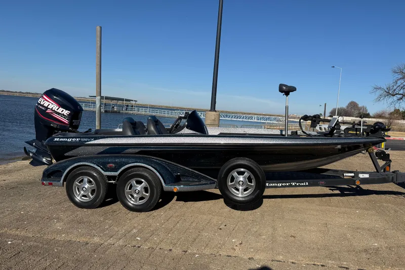 Slide: The Image of 2008 Ranger 198 VX boat on trailer by the water, featuring Evinrude engine. - 25