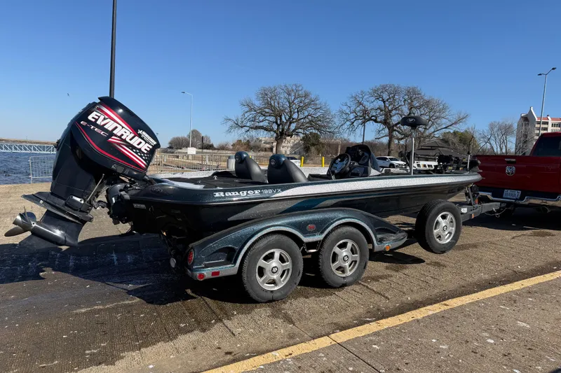 Slide: The Image of 2008 Ranger 198 VX boat on trailer by a lake, clear sky, and parked truck nearby. - 4