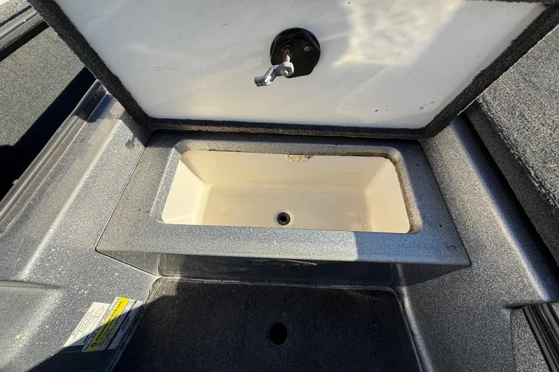 Slide: The Image of Open storage compartment in 2008 Ranger 198 VX boat, featuring a drain plug. - 43
