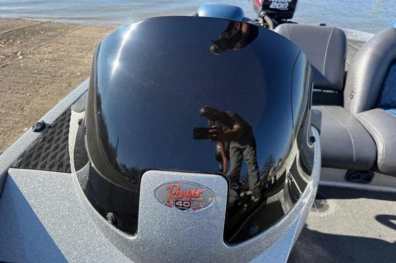 Slide: The Image of 2008 Ranger 198 VX boat console with reflective surface and logo, near water. - 51